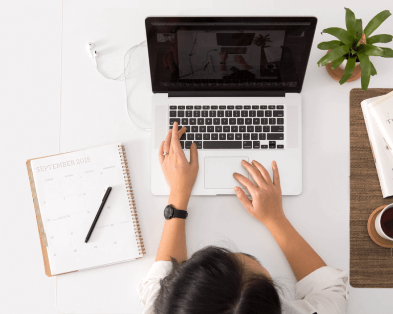 A sleek, uncluttered tech setup (laptop, planner, coffee cup) showing an efficient workspace, symbolizing streamlined tools.